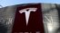 Logo produsen kendaraan listrik Tesla di dekat kompleks perbelanjaan di Beijing, China, 5 Januari 2021. (Foto: REUTERS/Tingshu Wang)