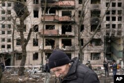 An elderly man walks outside an apartment block which was destroyed by an artillery strike in Kyiv, Ukraine, March 14, 2022.