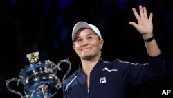 FILE - Ash Barty of Australia waves as she holds the Daphne Akhurst Memorial Cup after defeating Danielle Collins of the U.S., in the women's singles final at the Australian Open tennis championships in Melbourne, Australia on Jan. 29, 2022.