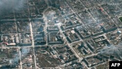 This Maxar satellite image taken and released on March 21, 2022 shows an overview of burning buildings and the Mariupol theater in Mariupol, Ukraine.