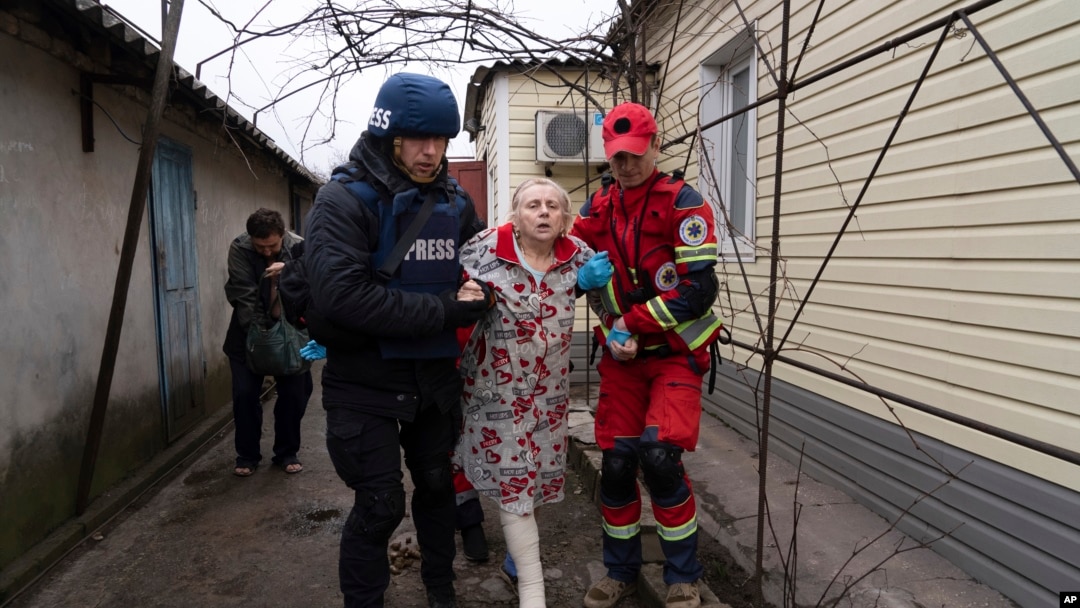 Fotograf Associated Pressa Evgenij Maloletka pomaže bolničaru da preveze ženu povrijeđenu tokom granatiranja u Mariupolju, na istoku Ukrajine, 2. marta 2022.