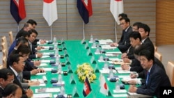 In this file photo taken on October 8, 2018, Japanese Prime Minister Shinzo Abe, right, and Cambodia's Prime Minister Hun Sen, left, attend their meeting at Abe's office in Tokyo. (AP Photo/Eugene Hoshiko, Pool)