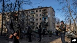 Polisi berjaga di lokasi gedung perumahan yang hancur akibat serangan bom Rusia di Kyiv, Ukraina, pada 18 Maret 2022. (Foto: AP/Rodrigo Abd)