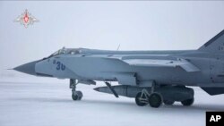 This photo taken from video provided by the Russian Defense Ministry Press Service on Saturday, Feb. 19, 2022, shows a MiG-31K fighter of the Russian air force carrying a Kinzhal hypersonic cruise missile parked at an air field during a military drills.