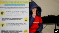 File - A Volunteer at the International Humanitarian Group Save the Children Sits Next To a Banner Giving Advice on Personal Safety Border, In Siret, Romania, March 7, 2022.