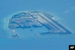 Chinese structures and buildings at the man-made island on Mischief Reef at the Spratlys group of islands in the South China Sea are seen on Sunday March 20, 2022. (AP Photo/Aaron Favila)