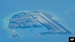 Chinese structures and buildings at the man-made island on Mischief Reef at the Spratlys group of islands in the South China Sea are seen on Sunday March 20, 2022. (AP Photo/Aaron Favila)