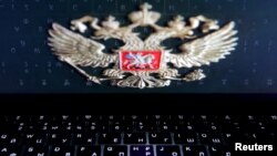 FILE - The coat of arms of Russia is reflected in a laptop screen in this illustration photo taken Feb. 12, 2019.