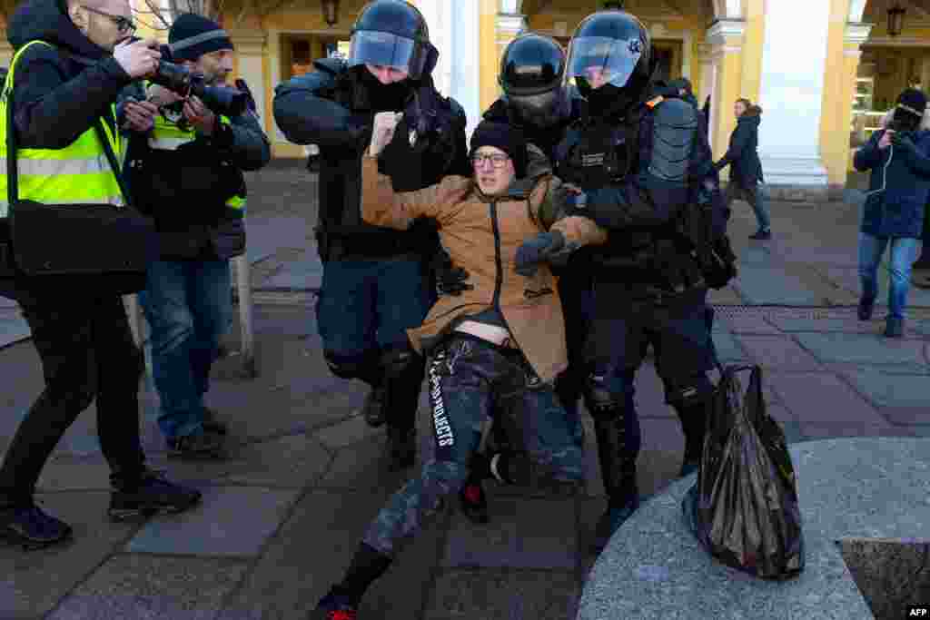 Sank Peterburq - Polis prezident Vladimir Putinin Ukraynaya hərbi müdaxiləsinə etiraz olaraq aksiya keçirən etirazçını saxlayır, 13 mart, 2022-ci il.