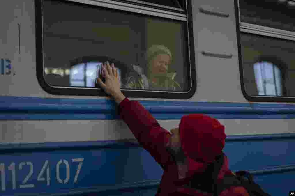 Displaced Ukrainians on a train heading to Poland say goodbye in Lviv, western Ukraine. The U.N. refugee agency says more than 3.5 million people have fled Ukraine since Russia&#39;s invasion.