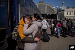 A mother embraces her son who escaped the besieged city of Mariupol and arrived at the train station in Lviv, western Ukraine, March 20, 2022.