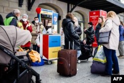 Ukrainian refugees wait at an information stand at the main railway station (Hauptbahnhof) in Dresden, eastern Germany, March 22, 2022.