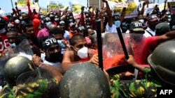 Police Special Task Force officers try to stop demonstrators during a protest against the rising living costs, outside President Gotabaya Rajapaksa's seafront office in Colombo, Sri Lanka.