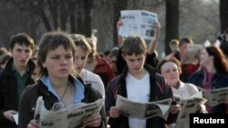 FILE - Belarussian opposition supporters read the opposition newspaper 'Nasha Niva' in public during a flash mob gathering in central Minsk April 28, 2006.