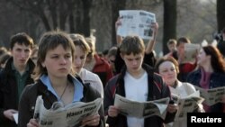 FILE - Belarusian opposition supporters read the opposition newspaper Nasha Niva in public during a flash mob gathering in central Minsk, April 28, 2006. The news outlet's operations and staff fled Belarus after its disputed 2020 election and continue to publish digitally. 