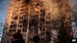 Ukrainian firefighters work in an apartment building after bombing in Kyiv, Ukraine, March 15, 2022. 