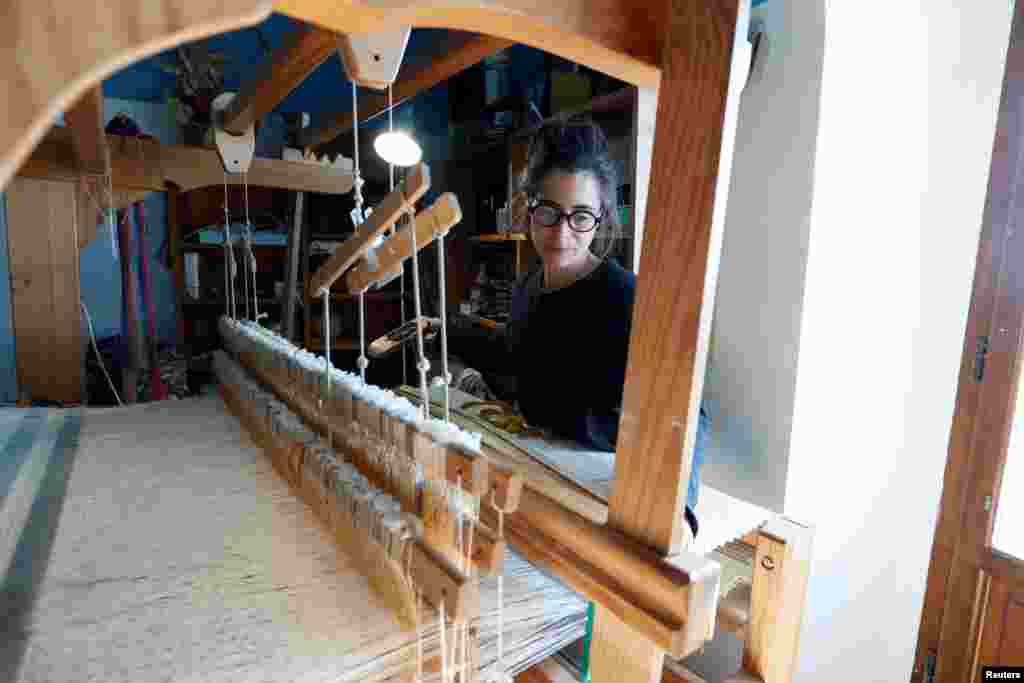 Valeria Befani, 47, resident of Rocca Calascio, uses a traditional loom to weave a carpet at her house and laboratory in the small village of Rocca Calascio, Italy, February 25, 2022. Italy counts about 1000 villages abandoned since the 1950 but in recent