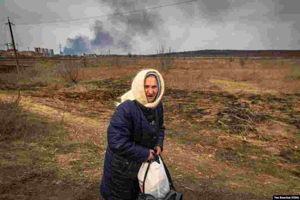 An elderly woman finally leaves Irpin after days hiding in a shelter to survive the shelling. Irpin, Ukraine, March 12, 2022. (Yan Boechat/VOA)