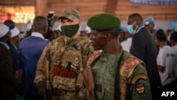 Un agent de sécurité privé du groupe russe Wagner et d'un soldat centrafricain à Bangui, le 18 mars 2022.