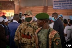 A private security guard from the Russian group Wagner (L) stands next to a Central African Republic soldier during a rally of the United Hearts Movement political party at the Omnisport Stadium in Bangui on March 18, 2022. (Barbara Debout/AFP)