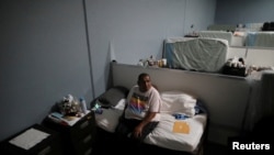 FILE - Roland Flores, 48, sits on a bed at the Fullerton Navigation Center, a homeless shelter in Fullerton, California, U.S. March 11, 2022. (REUTERS/David Swanson/File Photo)
