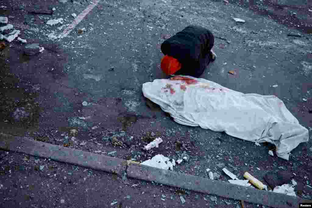 A man mourns next to the body of his mother, who was killed when a Russian missile hit a residential building in Kyiv, amid Russia&#39;s invasion of Ukraine.