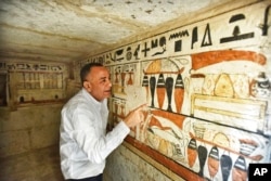 مصطفی وزیری، دبیرکل شورای عالی آثار باستانی مصر، دیوارهای تزئین شده مقبره‌هایی که در سقاره کشف شده‌اند را نشان می‌دهد - ۱۹ مارس ۲۰۲۲