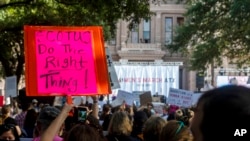FILE - People attend the Women's March ATX rally, Oct., 2, 2021, at the Texas State Capitol in Austin, Texas. 