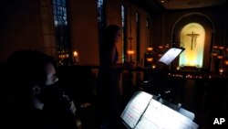 FILE - Violinist Michael Ferri, left, accompanies mezzo-soprano Karolina Wojteczko in a performance of traditional Ukrainian chants and folk songs during a benefit concert for Ukraine at St. Thomas More Catholic Chapel in New Haven, Conn., March 16, 2022.