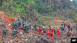 En esta imagen, distribuida por la agencia noticiosa Xinhua, rescatistas buscan las cajas negras en el lugar donde se estrelló un avión, en el condado de Tengxian, en la región autónoma china de Guangxi Zhuang, el 22 de marzo de 2022. 