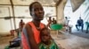 FILE - Nyayiar Kuol holds her severely malnourished 1-year-old daughter, Chuoder Wal, in a hospital run by Medicines Sans Frontieres (Doctors Without Borders) in Old Fangak in Jonglei state, South Sudan, Dec. 28, 2021.