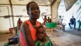 FILE: Nyayiar Kuol holds her severely malnourished 1-year-old daughter, Chuoder Wal, in a hospital run by Medicines Sans Frontieres in Old Fangak in Jonglei state, South Sudan, Dec. 28, 2021.