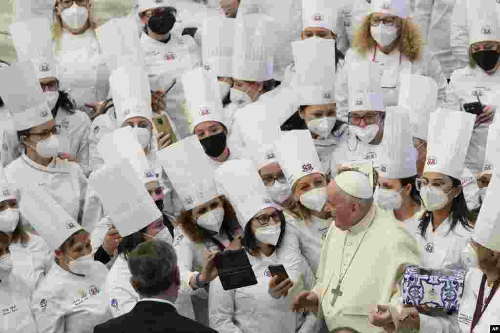 Pope Francis poses for a photo with women of the Italian Chefs Federation at the end of his weekly general audience in the Paul VI Hall, at the Vatican.