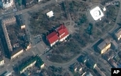 This satellite image provided by Maxar Technologies shows the Mariupol Drama Theater in Mariupol, Ukraine, March 14, 2022. Ukrainian officials say Russian forces destroyed the theater where hundreds of people were sheltering. There was no immediate word o