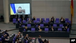 Members of the German parliament Bundestag listen to Ukraine President Volodymyr Zelenskyy during his virtual address to the parliament at the Reichstag Building, in Berlin, March 17, 2022.