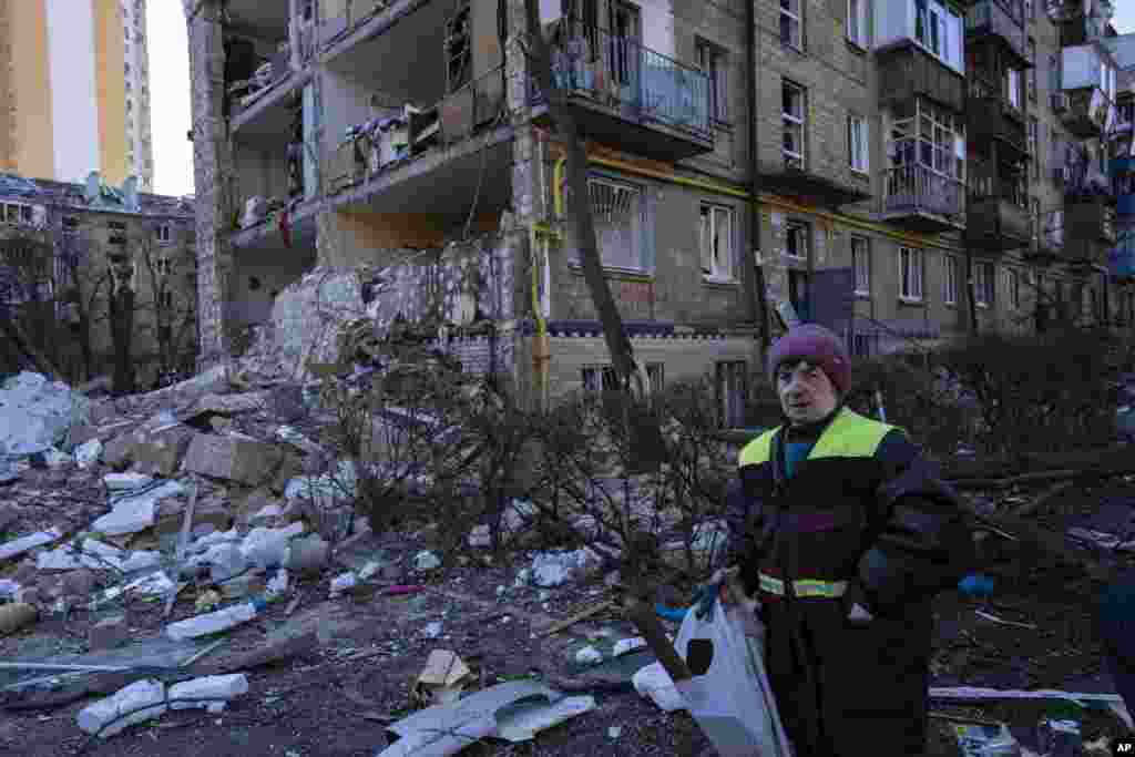 Una mujer camina junto al sitio donde un bombardeo dañó edificios residenciales en Kiev, Ucrania, el viernes 18 de marzo de 2022. Las fuerzas rusas intensificaron su ataque contra las ciudades ucranianas el viernes, con nuevos ataques con misiles y bombardeos en los bordes de la capital, Kiev, y la ciudad occidental de Lviv, mientras los líderes mundiales presionaban para que se investigaran los repetidos ataques del Kremlin contra objetivos civiles, incluidas escuelas, hospitales y zonas residenciales.&nbsp;