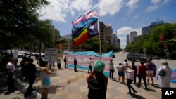 FILE - Demonstrators gather at the Texas State Capitol to speak against transgender-related bills being considered in the legislature, May 20, 2021, in Austin.