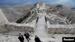 Franco Cagnoli, 39, caretaker of the Rocca Calascio castle explains to tourists the history of the castle, February 25, 2022. (REUTERS/Remo Casilli)