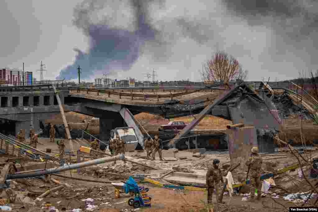 Three men are arrested by the Ukrainian army after being accused of looting houses in Irpin, Ukraine, March 12, 2022. (Yan Boechat/VOA)