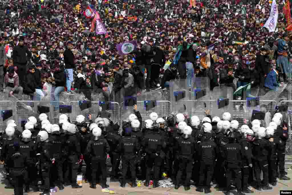 Police officers stand guard as supporters of pro-Kurdish Peoples&#39; Democratic Party (HDP) gather to celebrate Nowruz, which marks the arrival of spring, in Diyarbakir, Turkey.