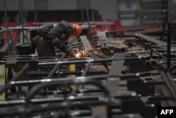 FILE - A worker at the Novatek's Offshore Superfacility Construction Center (OSCC) for the world's first facility production of natural gas liquefaction trains in the village of Belokamenka in the Murmansk Region, Russia, Nov. 29, 2021.