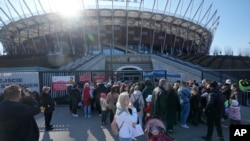 Hundreds of refugees from Ukraine wait in line to apply for Polish ID numbers. The application points are not able to handle all those interested and ask many of them to return later to the National Stadium in Warsaw, Poland, March 19, 2022.