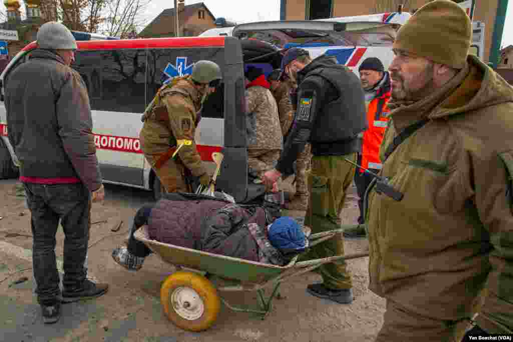 An elderly woman is carried away from the battle area and taken to a hospital in Kyiv. Irpin, Ukraine, March 12, 2022. (Yan Boechat/VOA)