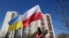 A man waves the Ukrainian and Polish flag during a demonstration in front of a building housing Russian diplomats in Warsaw, March 13, 2022. Poland's Internal Security Agency says it has identified 45 Russian secret service officers and associates 