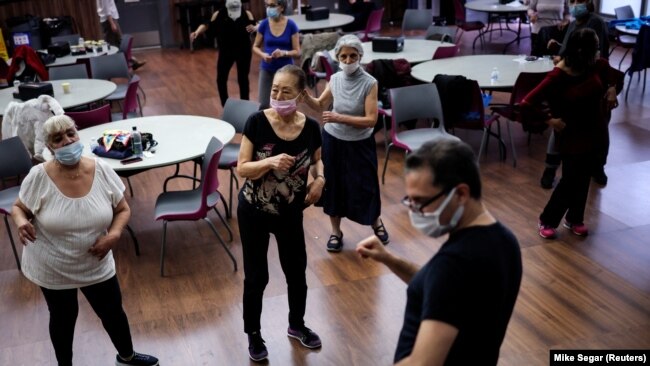 Walter Perez teaches a seniors dance class .They are able to socialize and get exercise. Picture taken March 7, 2022. (REUTERS/Mike Segar)