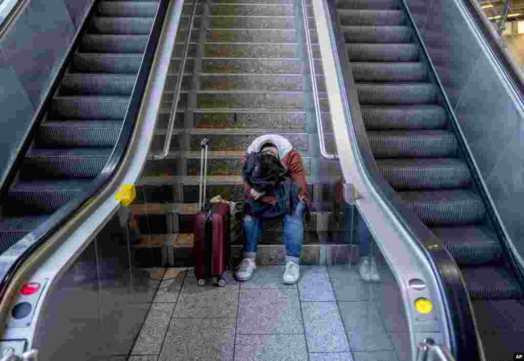 A stranded passenger rests in a terminal at the airport in Frankfurt, Germany.