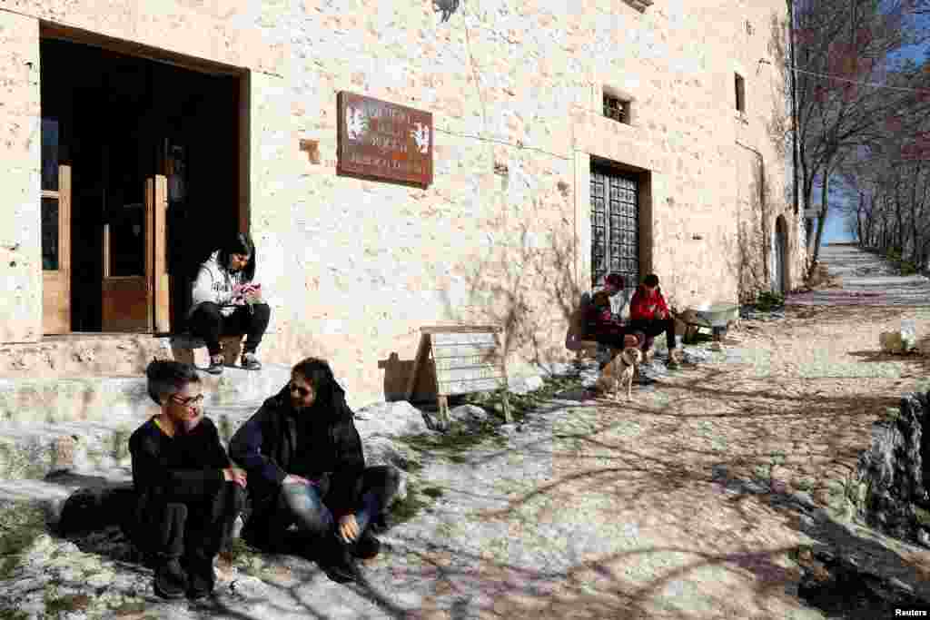 Residents of Rocca Calascio enjoy a sunny day in the small village of Rocca Calascio, Italy, February 25, 2022. Italy counts about 1000 villages abandoned since the 1950 but in recent years the trend has been reversed with young people trying to revive th