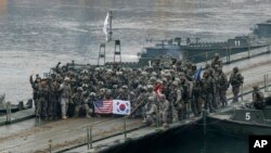 FILE - U.S. and South Korean army soldiers pose on a floating bridge on the Hantan river after a river crossing operation, part of an annual joint military exercise between South Korea and the United States in Yeoncheon, South Korea, Dec. 10, 2015.