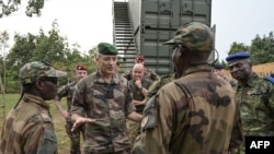 FILE - General Thierry Burkhard, 2nd left, Army Chief of Staff of the French Army, speaks to an Ivorian soldier during a visit to the International Counterterrorism Academy in Jaqueville, Ivory Coast, Feb. 7, 2022.