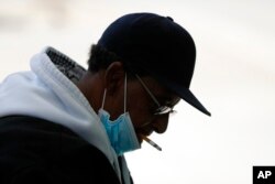 미국 미시간주 디트로이트 시내 버스 정류장 이용자가 마스크를 내린 채 흡연하고 있다. (자료사진)